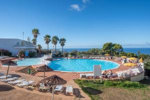 a pool with chairs and umbrellas at a resort at Sun Club El Dorado - All Inclusive in Llucmajor