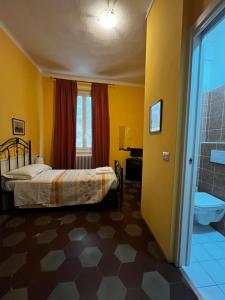 a bedroom with a bed and a bathroom with a shower at La Locanda Del Viandante in Bellano