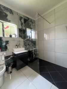 ein Badezimmer mit Waschbecken und Toilette in der Unterkunft Cozy Cottage on 5th Avenue in Johannesburg