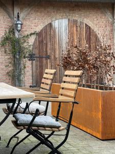 two chairs and a table in front of a door at Sams Cottage in Roermond