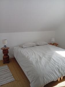 a bedroom with a white bed and two lamps at ricochets in Castillon