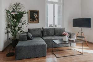 a living room with a gray couch and a table at The Hub Syros in Ermoupoli