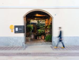 a person walking in front of a building at Boutique House in corte storica in Seregno