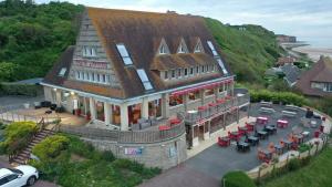an overhead view of a house with tables and chairs at Logis Hotel Du Casino Restaurant Le Mathelia in Vierville-sur-Mer