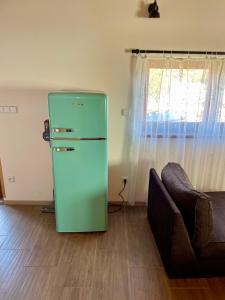 a green refrigerator in a living room with a couch at Wellness chata se saunou a vířivkou 2 in Žirovnice +12 photos