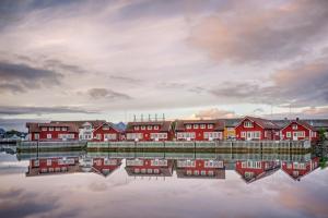 a row of red houses next to a body of water at Anker Brygge in Svolvær