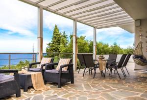 d'une terrasse avec des chaises et une table offrant une vue. dans l'établissement Villa Harmony, à Amoudi