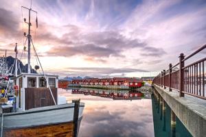 a boat is docked next to a dock at Anker Brygge in Svolvær