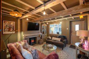 un salon avec un canapé et une cheminée dans l'établissement Purple Poppy Cottage, à Burton Joyce