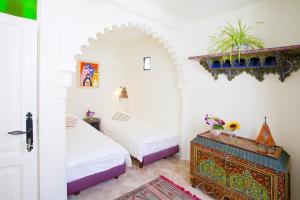 a bedroom with two beds and a table with flowers at Kasbah Rose in Tangier +34 photos