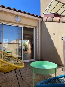 a patio with a table and a chair and a table at Elegant Marseille Prado Loft Walk to velodrome metro and Tram in Marseille