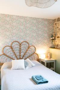 a bedroom with a bed with a large headboard at Le Clos Gagné in Bais