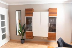 a living room with white cabinets and a potted plant at Ferienwohnung Herta in Breitenbach am Inn