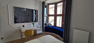 Un dormitorio con un espejo y un escritorio y una ventana. en Exclusive Panoramic APARTMENT, en Cracovia