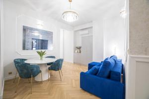 Una sala de estar con un sofá azul y una mesa. en Exclusive Panoramic APARTMENT, en Cracovia