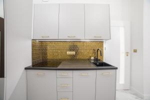 Una cocina con gabinetes blancos y un fregadero. en Exclusive Panoramic APARTMENT, en Cracovia 33 fotos más