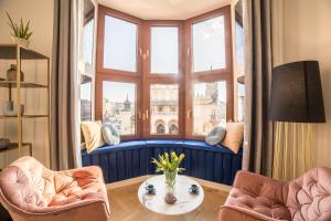 sala de estar con 2 sillas y mesa frente a una ventana en Exclusive Panoramic APARTMENT, en Cracovia