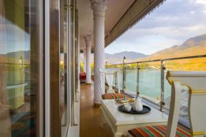 Un balcón con vista al agua y a las montañas. en ELIVAAS BYDM The Ganges 2 BHK Glasshouse Villa With Pvt Pool & Lift, en Rishīkesh