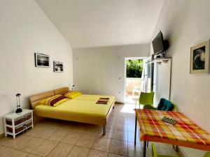 a bedroom with a yellow bed and a couch at Studio Apartments Darija in Brgulje