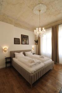 a large bed in a bedroom with a chandelier at Apartmá Juliana 1905 in Karlovy Vary