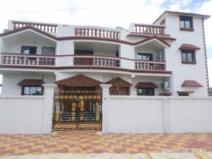 a white house with a gate and a fence at Udita Homestay Prayas in Shānti Niketan