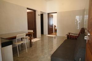 Una sala de estar con mesa de comedor y sillas. en Amani Beach Homestay, en Māvalli