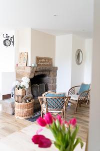 a living room with a stone fireplace and chairs at Le Clos Gagné in Bais