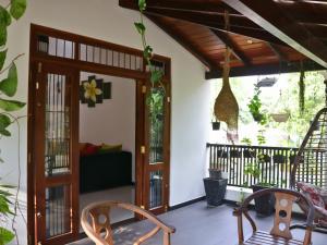 a porch with two chairs and a wooden door at Aqua Breeze Villa in Ja-Ela +13 photos