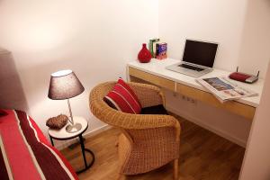Schlafzimmer mit einem Schreibtisch mit einem Laptop und einem Stuhl in der Unterkunft Ferienwohnung "Karmeliten Am Dom" in Regensburg