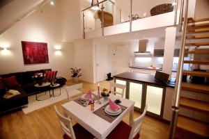 a living room and kitchen with a table and chairs at Ferienwohnung "Karmeliten Am Dom" in Regensburg