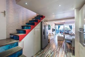 a staircase in a house with blue and red stairs at L'Anisé - Maison climatisée in Martigues +5 photos