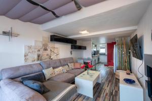 a living room with a couch and a table at L'Anisé - Maison climatisée in Martigues