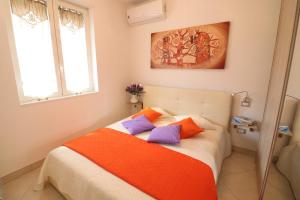 a bedroom with a bed with orange and purple pillows at Casa Francesca Otranto Modern 3 Guest Flat with AC & WiFi in Otranto