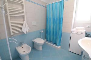 a blue bathroom with a toilet and a sink at Casa Francesca Otranto Modern 3 Guest Flat with AC & WiFi in Otranto