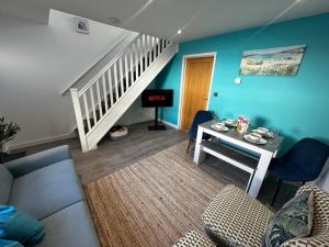 a living room with a couch and a table and a staircase at Sunny 2-Bedroom Coastal Stay with Free Parking in Great Yarmouth