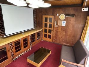 a living room with a flat screen tv and a couch at ポートサイドSasebo泉町 in Sasebo