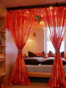 a bed with red curtains in a bedroom at Inselromantik Rügen, DZ Honeymoon in Dreschvitz +15 photos