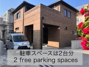 Un edificio de ladrillo con las palabras "plazas de aparcamiento gratuitas" en まちなかの家MANA, en Ishigaki Island