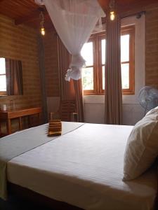 a bedroom with a large white bed with a window at DiDi Eco Home in Weligama