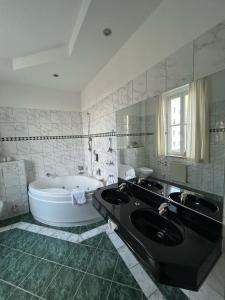 a bathroom with a tub and a sink and a bath tub at Hotel Uckermark in Prenzlau +29 photos