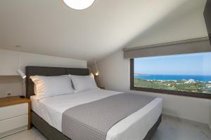 a bedroom with a bed and a large window at Theo Luxury Villas With Sea View in Agia Marina Nea Kydonias