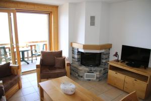 a living room with a fireplace and a television at Plein Ciel VA 031 - MOUNTAIN apartment 8 pers in Veysonnaz