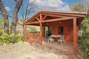 a wooden cabin with a table on a deck at Les Canonniers - Chalet avec Piscine in Solliès-Toucas