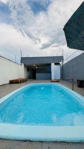 a large blue swimming pool in front of a building at Casa com piscina Bauru SP in Bauru