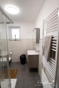 a white bathroom with a sink and a toilet at 18 Ferienwohnung im Fritz-Bleyl-Weg 16a EG in Burg auf Fehmarn