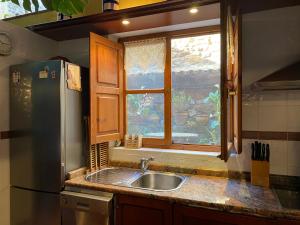a kitchen with a sink and a window at Casa Los Josuco in Collado +31 photos