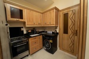 a kitchen with wooden cabinets and a washer and dryer at Oscar Apartment ! 1 ! in Luxor