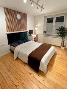 una camera da letto con un letto grande e un pavimento in legno di Bedroom with free parking a Borsdorf