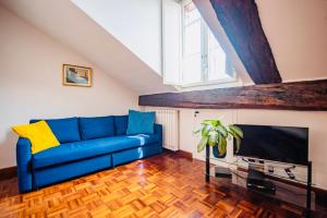 a living room with a blue couch and a tv at HOUSE with TERRACE in Turin