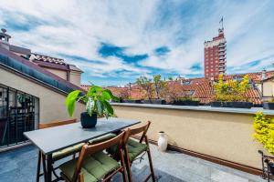 a patio with a table and chairs on a balcony at HOUSE with TERRACE in Turin